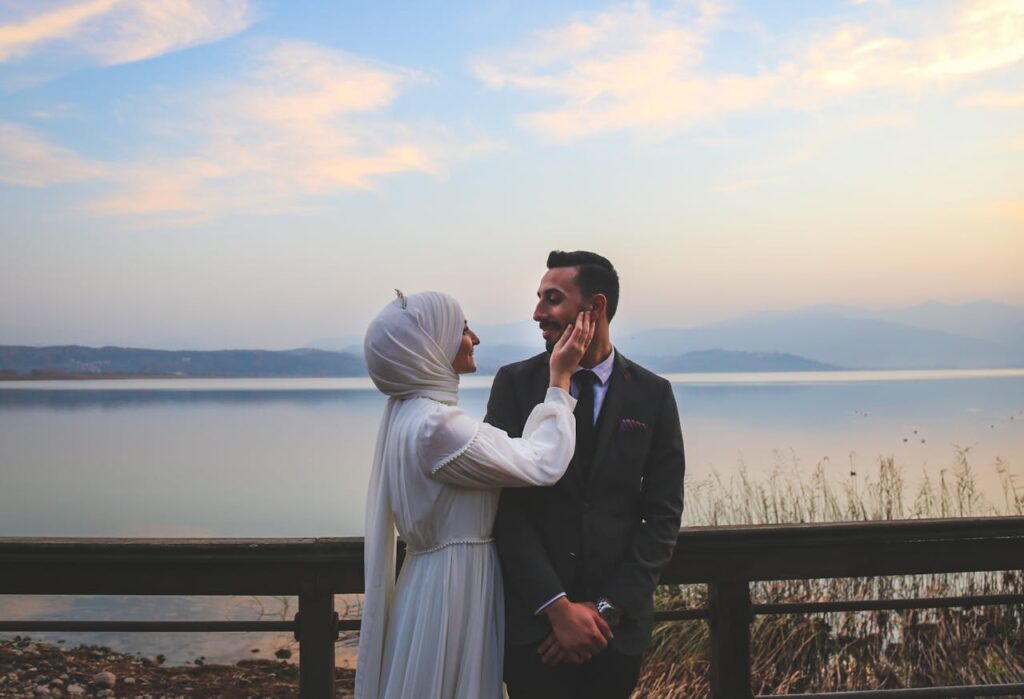 A joyful wedding couple in Sakarya, Turkey, posing by a tranquil lake at sunset.