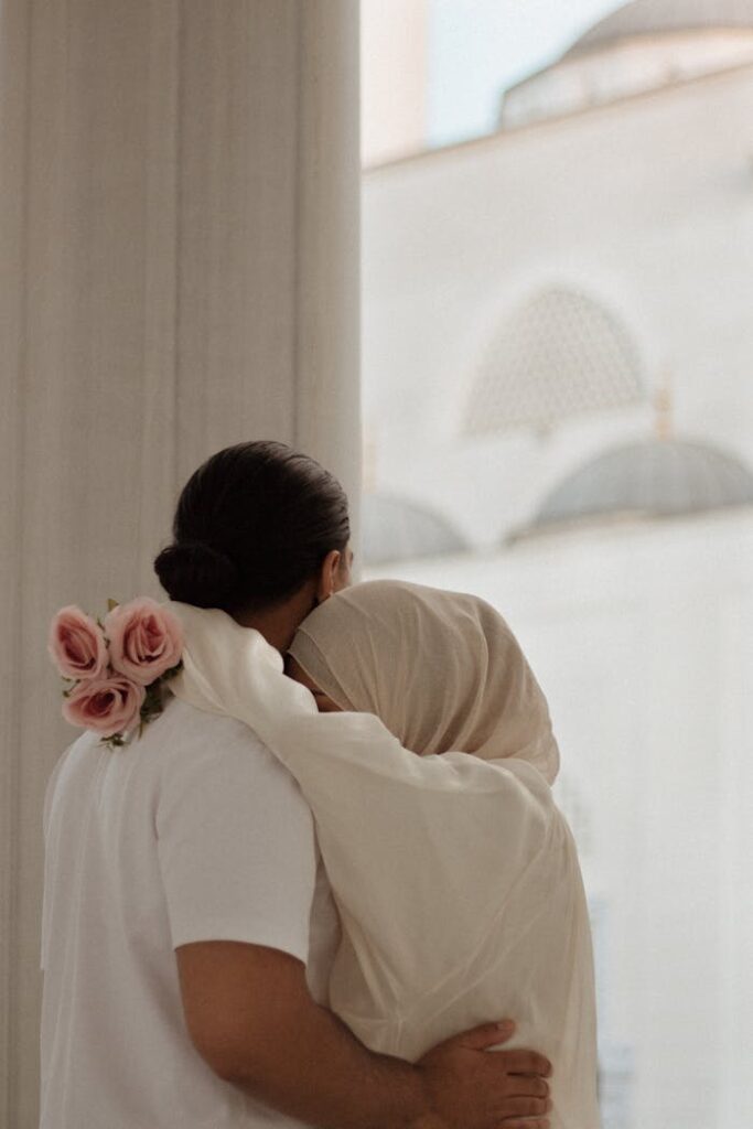 Couple lovingly embracing with a subtle rose bouquet, symbolizing unity and affection.