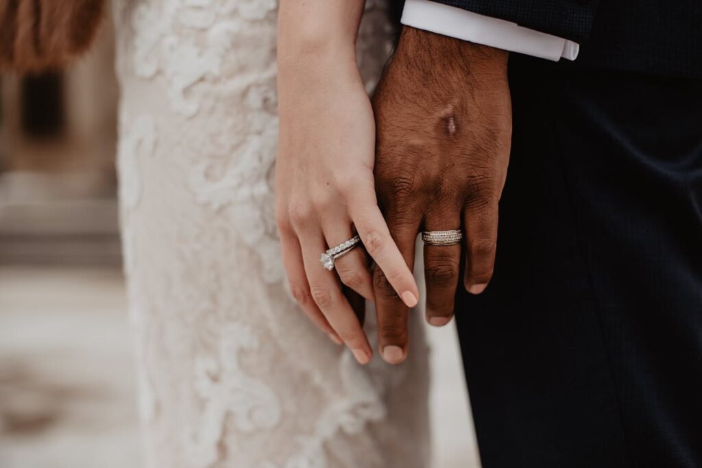 Two clasped hands showing wedding rings symbolizing unity and love in Syracuse.